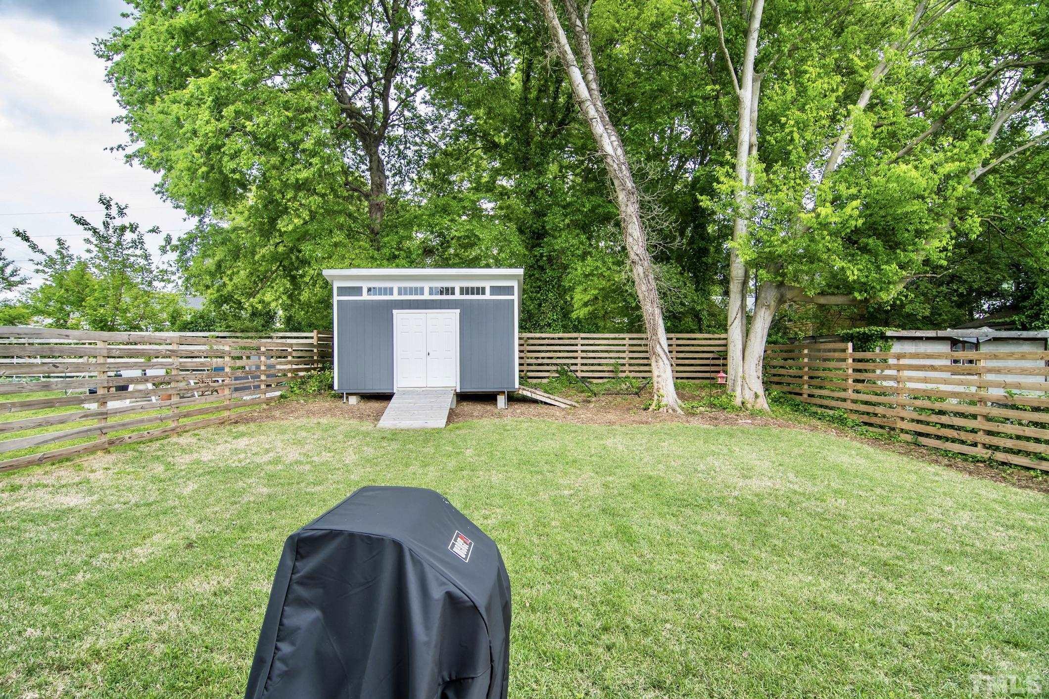 1309 South East Street Raleigh, NC 27601 - Photo 27 of 29 a view of a backyard with wooden fence and large trees