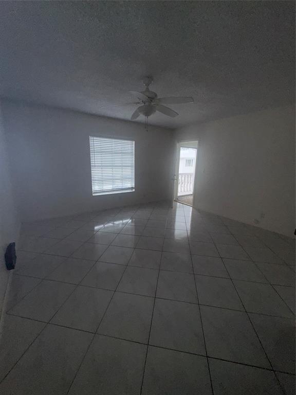 2220 Northeast 68th Street, Unit 1031 Fort Lauderdale, FL 33308 - Photo 4 of 12 en empty room with windows and fan