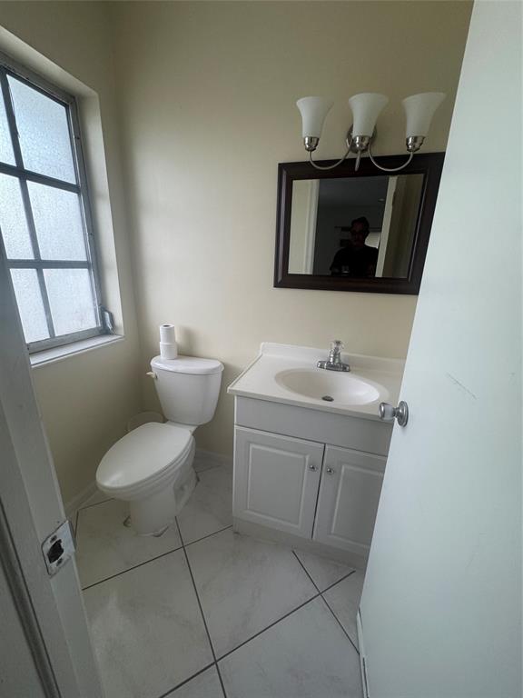 2220 Northeast 68th Street, Unit 1031 Fort Lauderdale, FL 33308 - Photo 8 of 12 a bathroom with a sink toilet and mirror