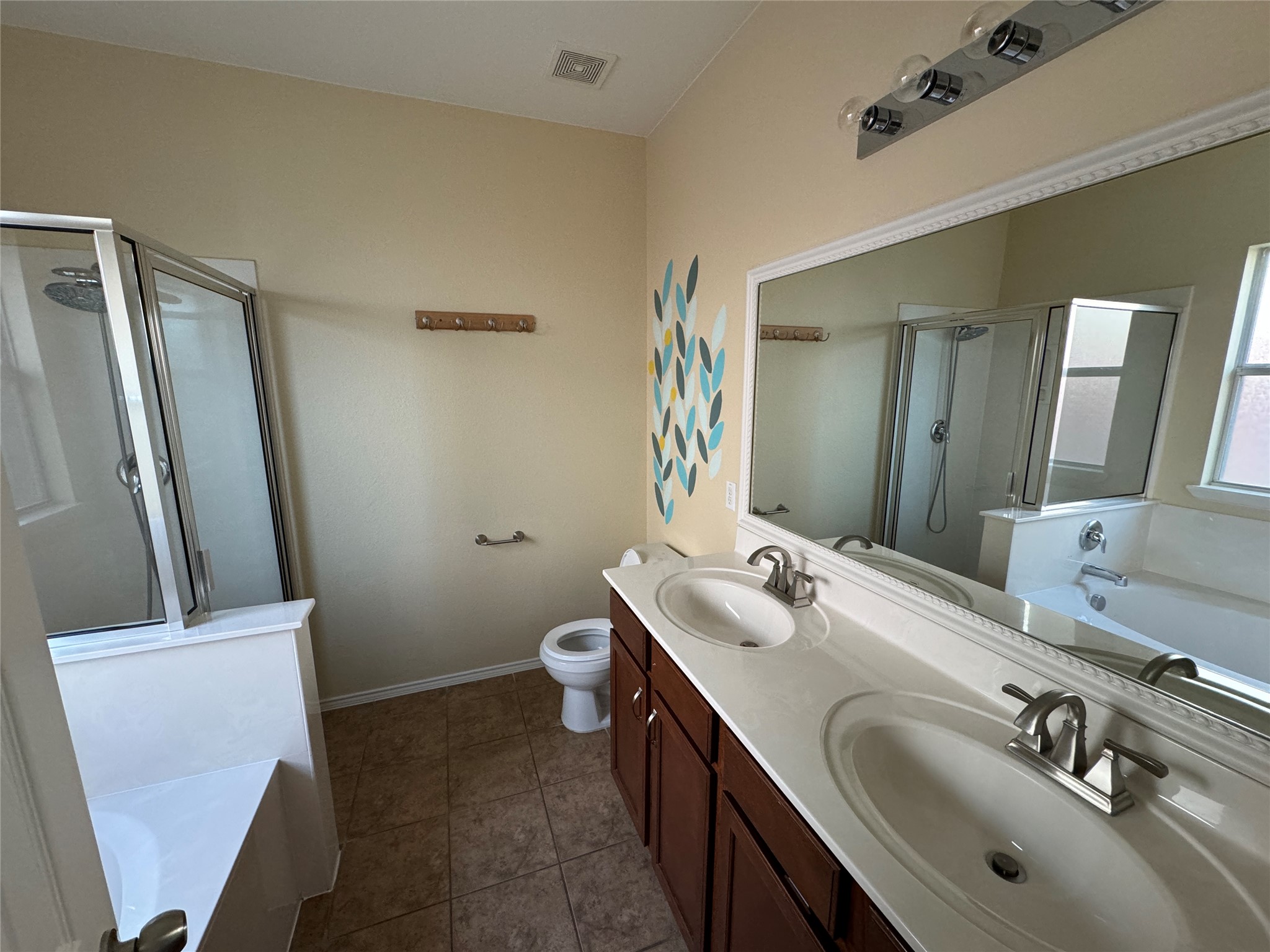 147 Pine Arbol Buda, TX 78610 - Photo 5 of 7 Master bathroom featuring a bath, a shower stall, double vanity, and dark tile patterned floors