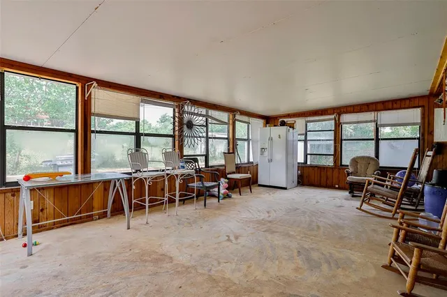 a bedroom with a bed and a large window with wooden floor