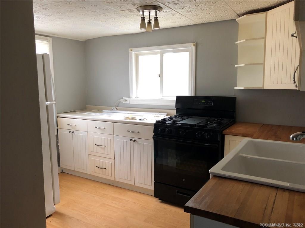 144 Wetmore Avenue, Unit 1 Winchester, CT 06098 - Photo 2 of 4 a kitchen with a sink stove and refrigerator