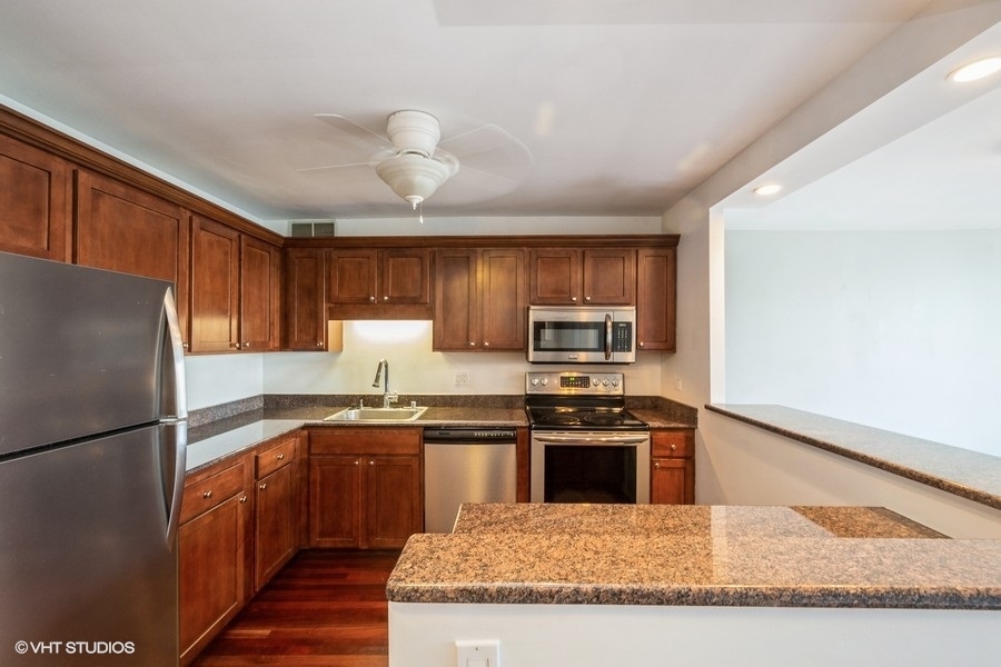 Undisclosed Address Chicago, IL 60611 - Photo 4 of 19 a kitchen with stainless steel appliances granite countertop a refrigerator a stove a sink and a microwave