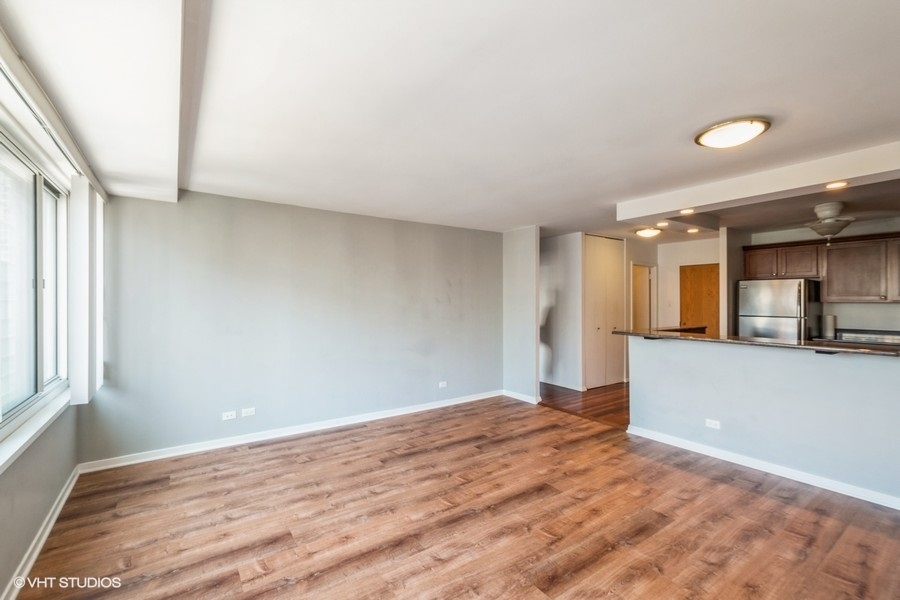 Undisclosed Address Chicago, IL 60611 - Photo 5 of 19 a view of a big room with wooden floor and a window
