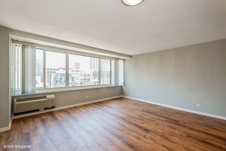 Undisclosed Address Chicago, IL 60611 - Photo 6 of 19 a view of an empty room with wooden floor and a window