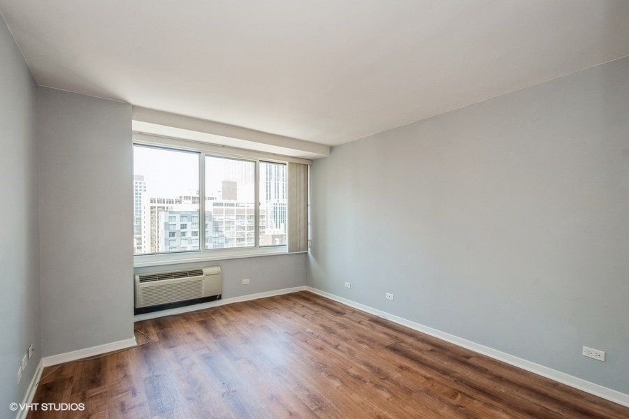 Undisclosed Address Chicago, IL 60611 - Photo 7 of 19 an empty room with wooden floor and windows