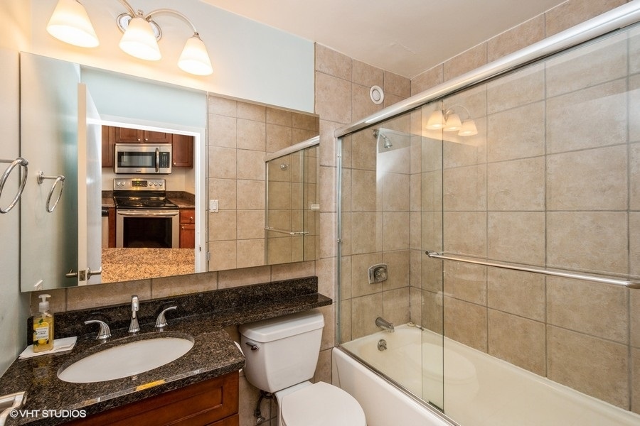 Undisclosed Address Chicago, IL 60611 - Photo 9 of 19 a bathroom with a sink double vanity granite tub and shower