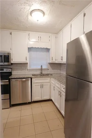 a kitchen with granite countertop cabinets and steel stainless steel appliances