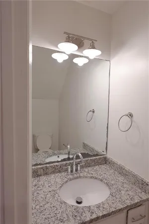 a bathroom with a granite countertop sink and a mirror