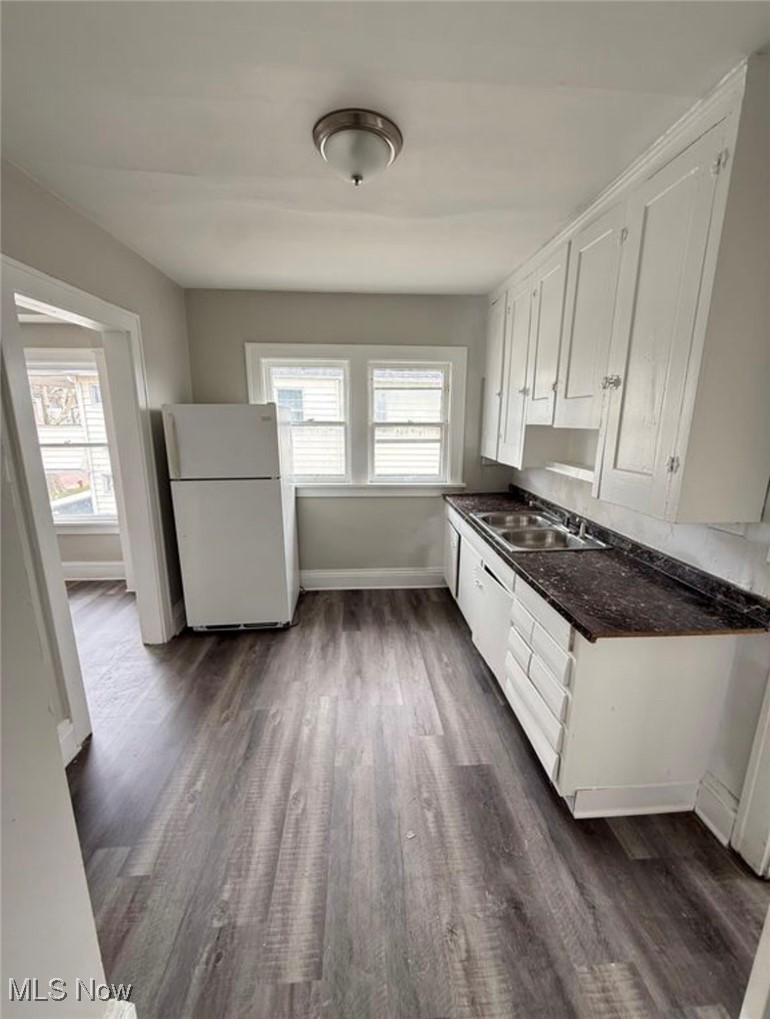 1743 Algonac Road Cleveland, OH 44112 - Photo 7 of 19 Kitchen with white cabinets, dark countertops, freestanding refrigerator, and dark wood-style floors