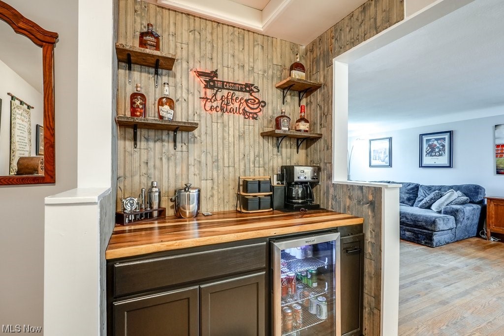 4828 South Sedgewick Road Cleveland, OH 44124 - Photo 7 of 19 Bar featuring beverage cooler, light wood-type flooring, and wood counters