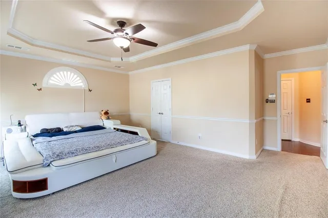 a spacious bedroom with a bed and ceiling fan