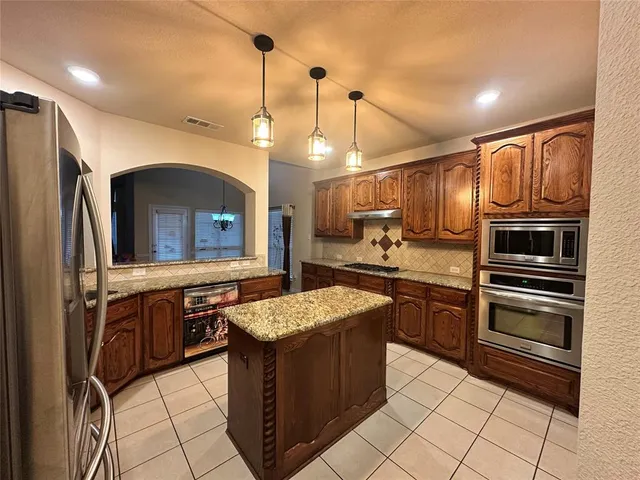 a kitchen with stainless steel appliances granite countertop a sink and a refrigerator