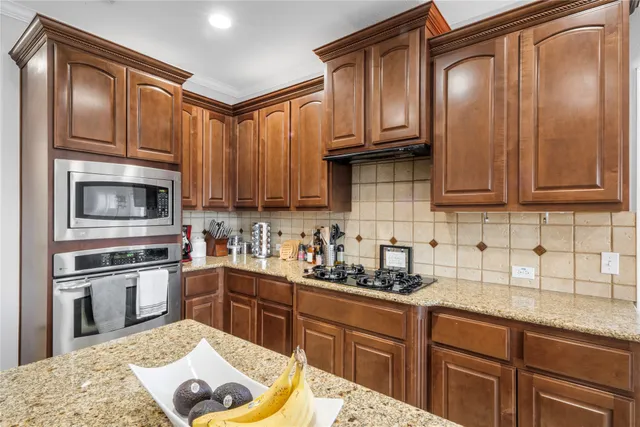 a kitchen with stainless steel appliances granite countertop a sink stove and microwave