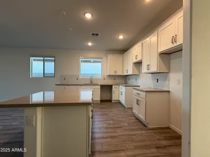 a kitchen with a refrigerator sink and cabinets