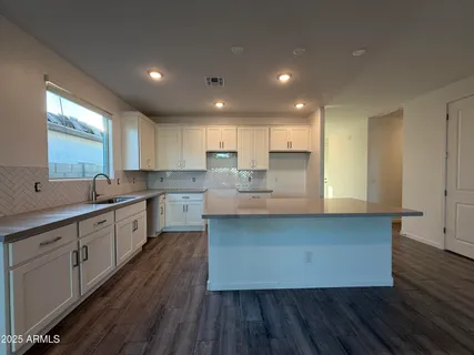 a large kitchen with cabinets wooden floor and stainless steel appliances