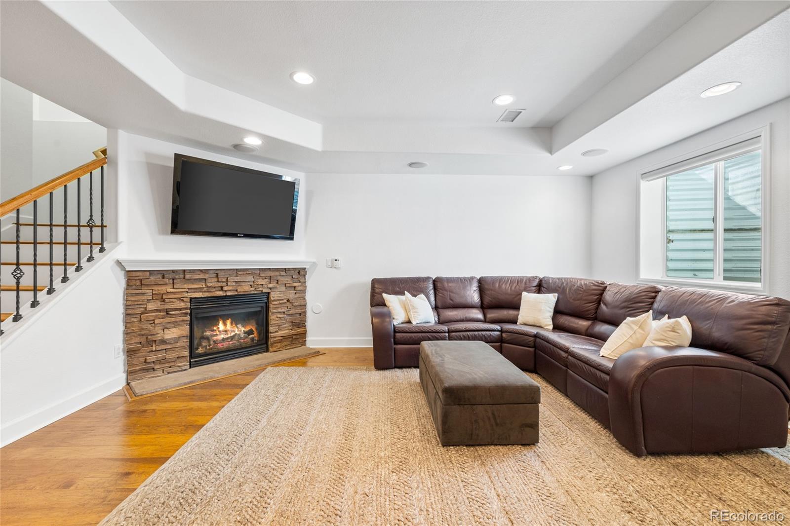 10451 Meadowleaf Way Highlands Ranch, CO 80126 - Photo 24 of 39 a living room with furniture a fireplace and a flat screen tv