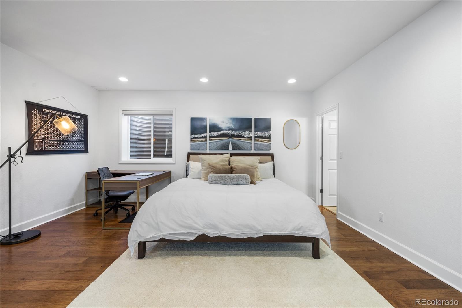 10451 Meadowleaf Way Highlands Ranch, CO 80126 - Photo 25 of 39 a bedroom with a large bed and wooden floor