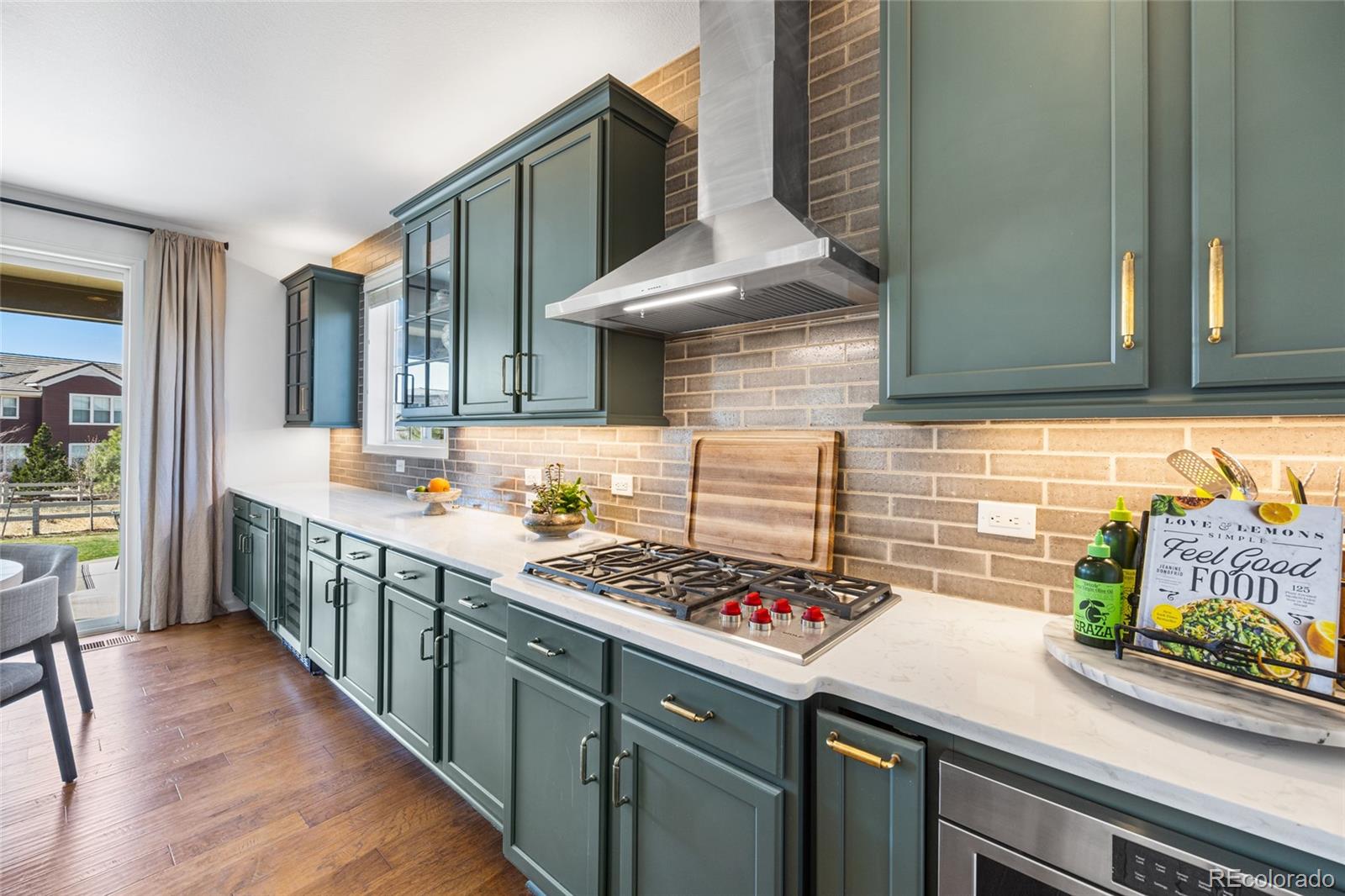 10451 Meadowleaf Way Highlands Ranch, CO 80126 - Photo 5 of 39 a kitchen with stainless steel appliances a sink a stove and wooden floor