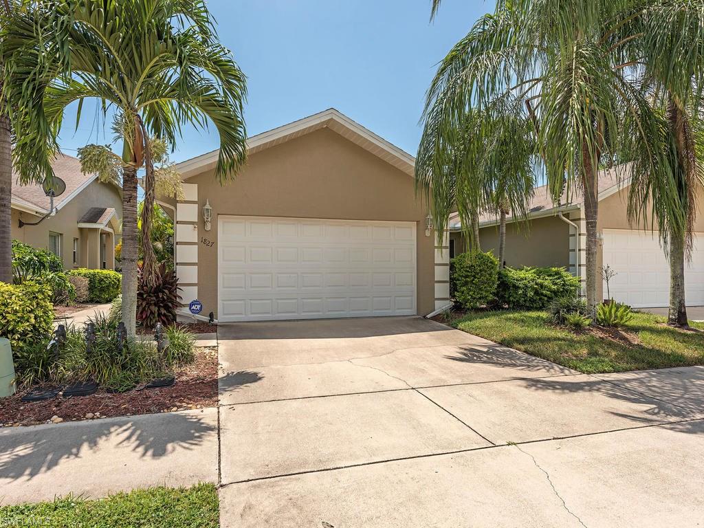 1827 West Crown Pointe Boulevard Naples, FL 34112 - Photo 1 of 12 a front view of a house with garden