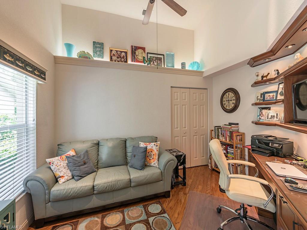 1827 West Crown Pointe Boulevard Naples, FL 34112 - Photo 11 of 12 a living room with furniture a clock on wall and a window