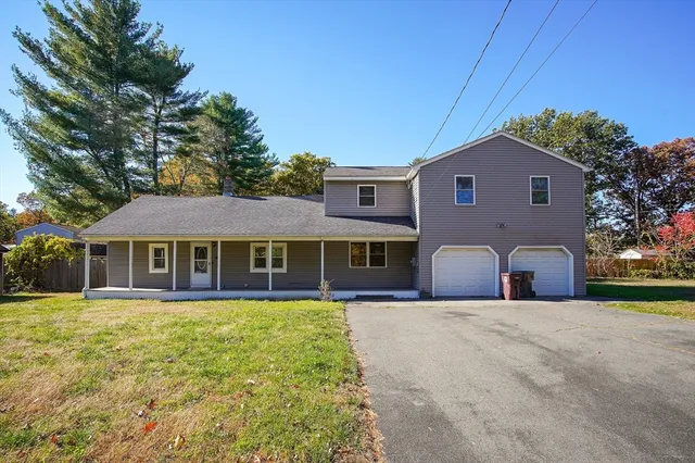 a front view of a house with a yard and trees