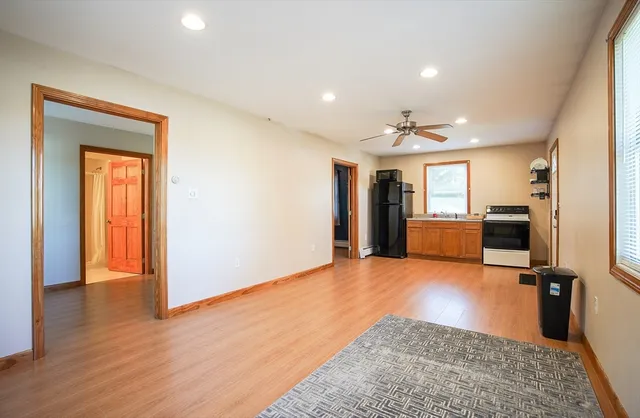 a view of a hallway with wooden floor and a living room