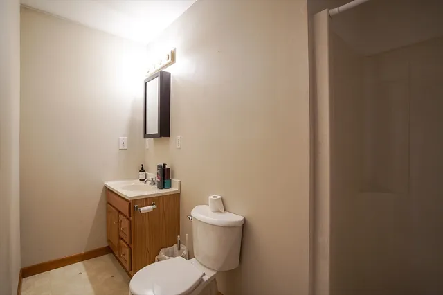 a bathroom with a toilet sink and mirror