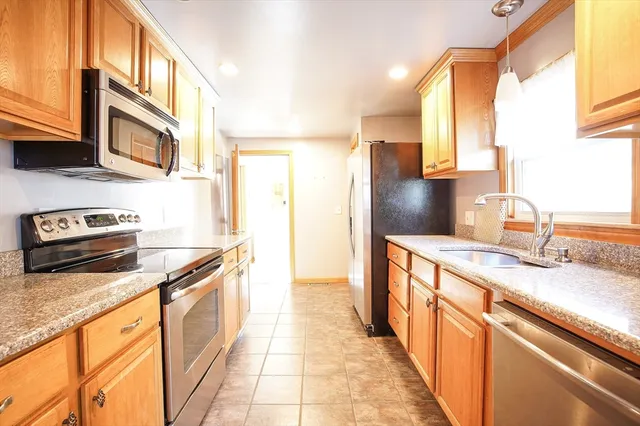 a kitchen with stainless steel appliances granite countertop a sink stove and refrigerator