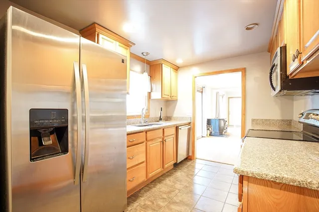 a kitchen with stainless steel appliances granite countertop a refrigerator and a sink