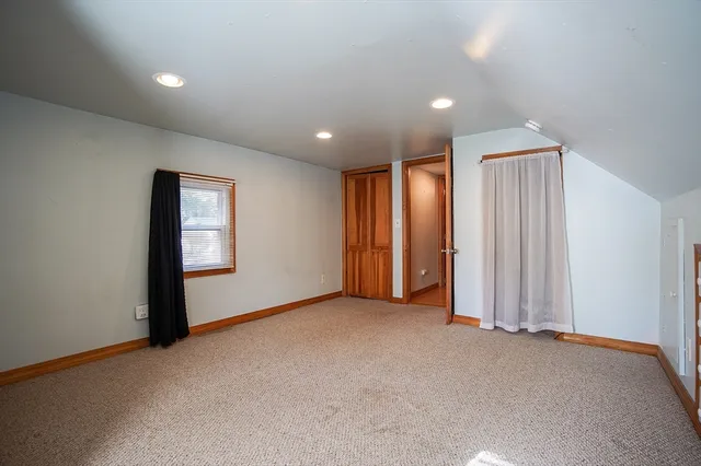 an empty room with windows and closet