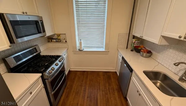 a kitchen with wooden floor and a stove top oven