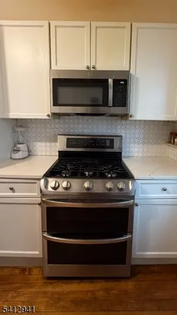 a stove top oven sitting inside of a kitchen
