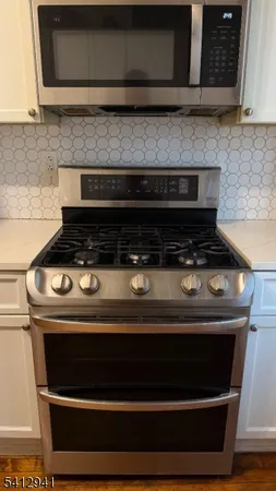 a stove top oven sitting inside of a kitchen