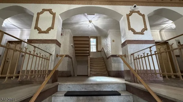 a view of staircase with lots of frames on wall and a painting