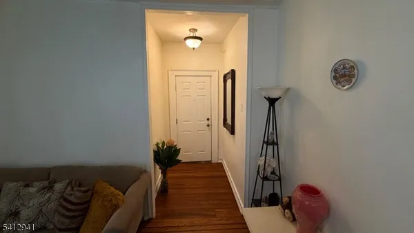 a hallway with front door wooden floor and a chandelier