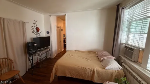 a bedroom with a bed and a flat tv screen on a dresser