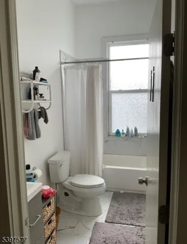 a bathroom with a toilet a bath tub and a shower