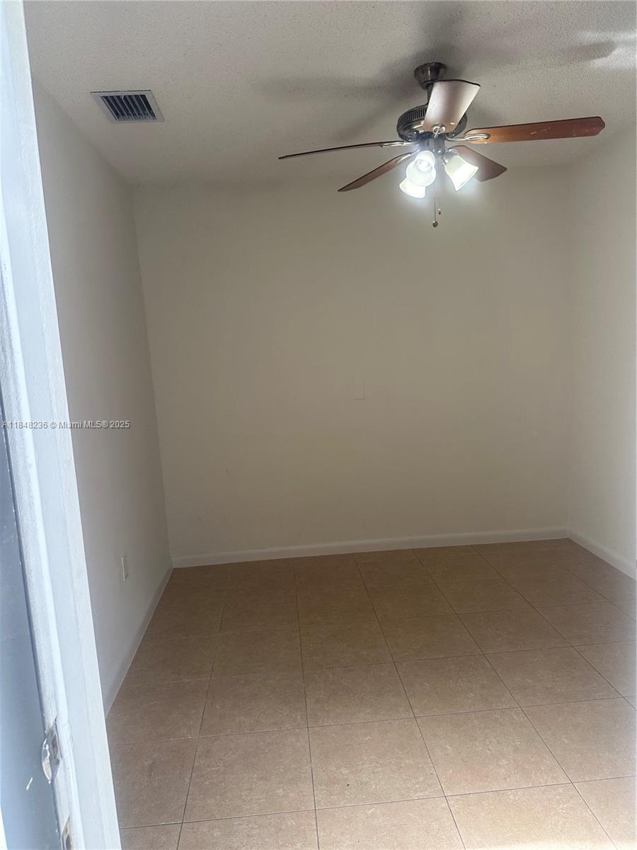 15882 Southwest 138th Court Miami, FL 33177 - Photo 9 of 11 en empty room with a chandelier fan