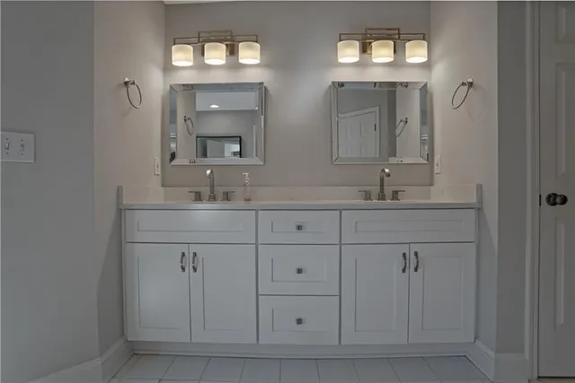 a bathroom with double sink and a mirror
