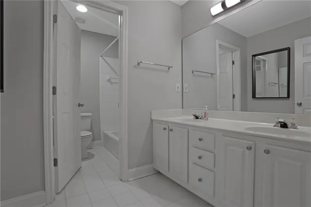 a spacious bathroom with a double vanity sink a large mirror and a shower