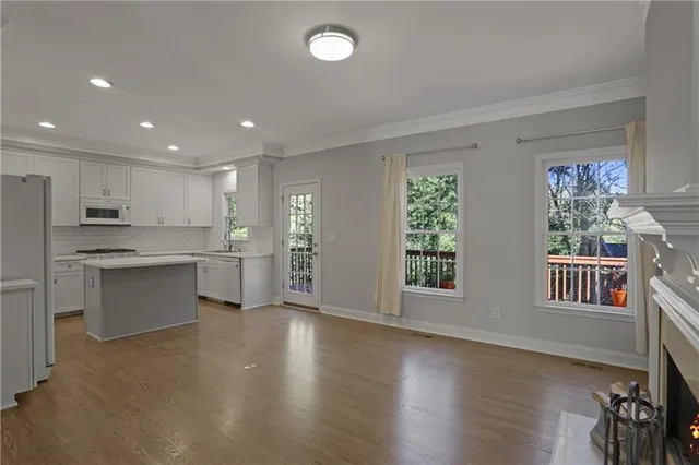 a open kitchen with white cabinets and wooden floor