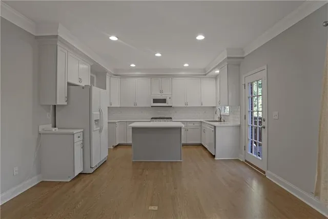 a kitchen with white cabinets and stainless steel appliances