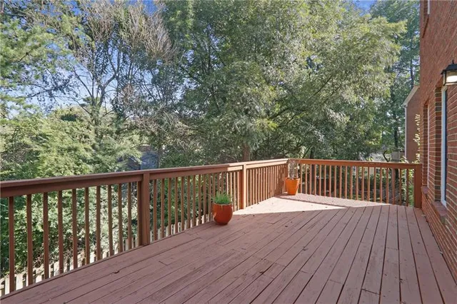 a balcony with wooden floor and trees