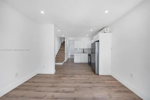 a view of a kitchen with a sink and refrigerator