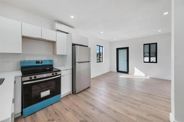 a kitchen with wooden floors and stainless steel appliances