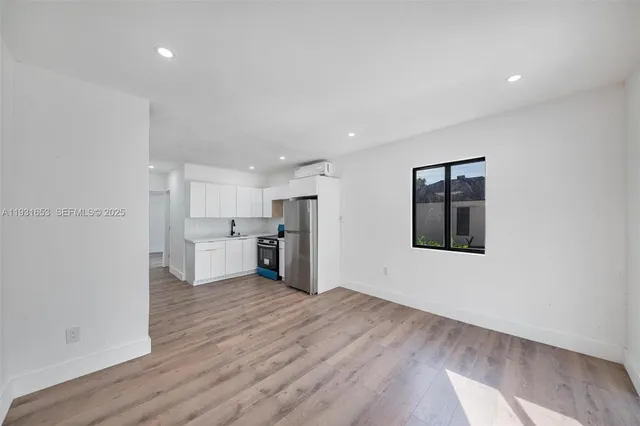 a view of a kitchen with a sink and a refrigerator