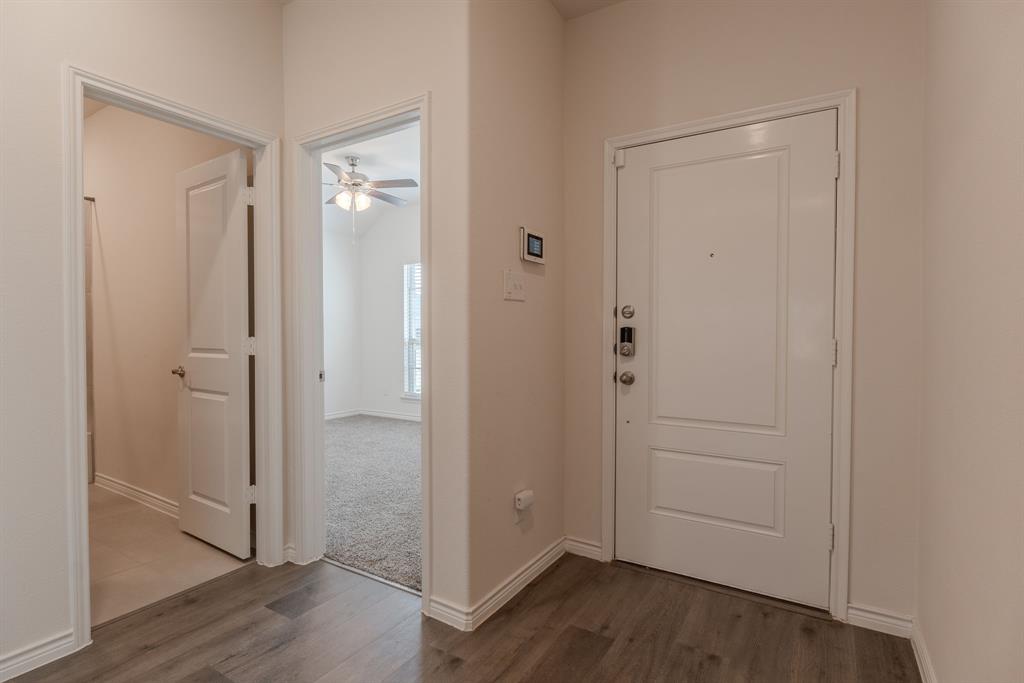 2902 Trusting Way Aubrey, TX 76227 - Photo 5 of 38 Foyer featuring wood-finish flooring, white panel doors, and a smart lock entry system
