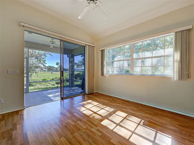a view of an empty room with window and wooden floor
