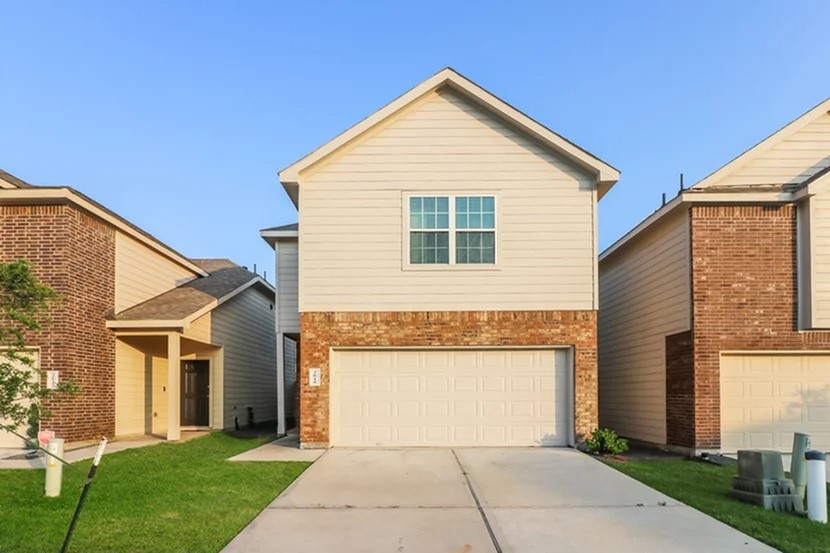 a front view of a house with a yard and garage